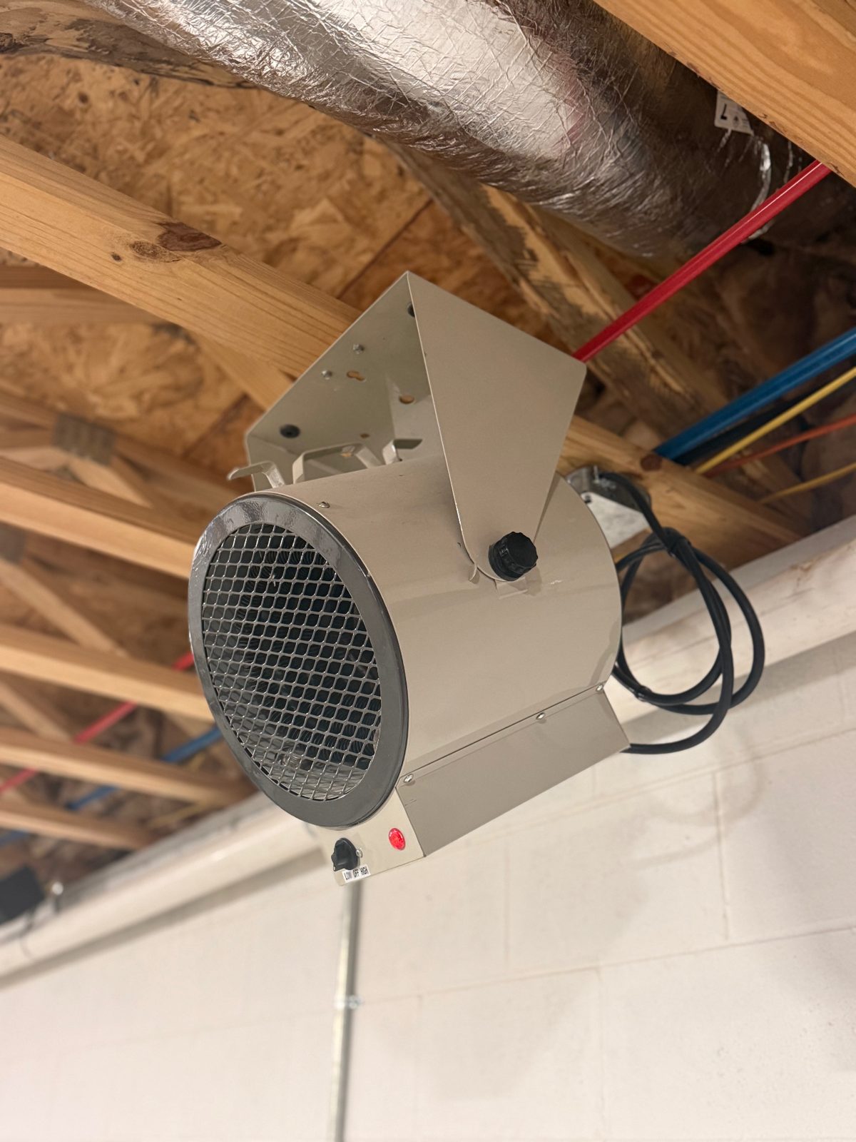 Heavy duty 240 volt electric heater mounted to ceiling joists in a garage