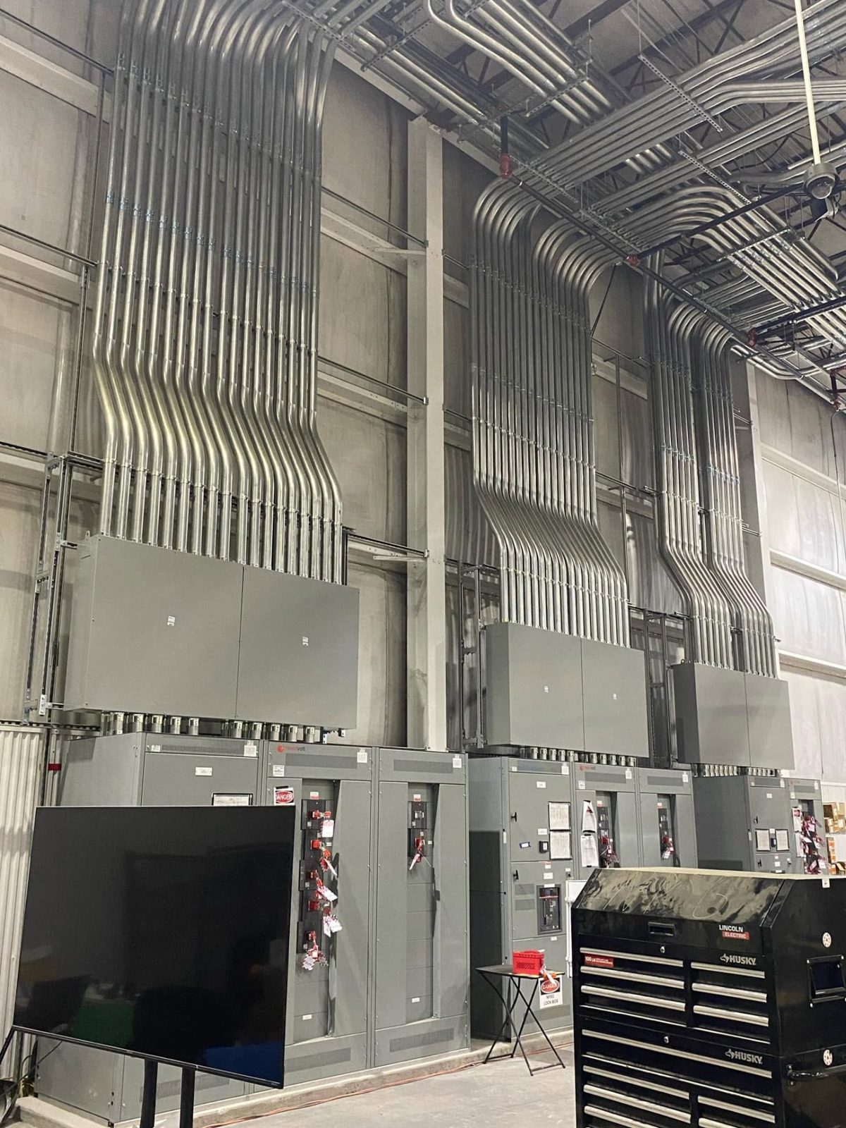 Commercial electrical switchgear installation with multiple conduit runs
