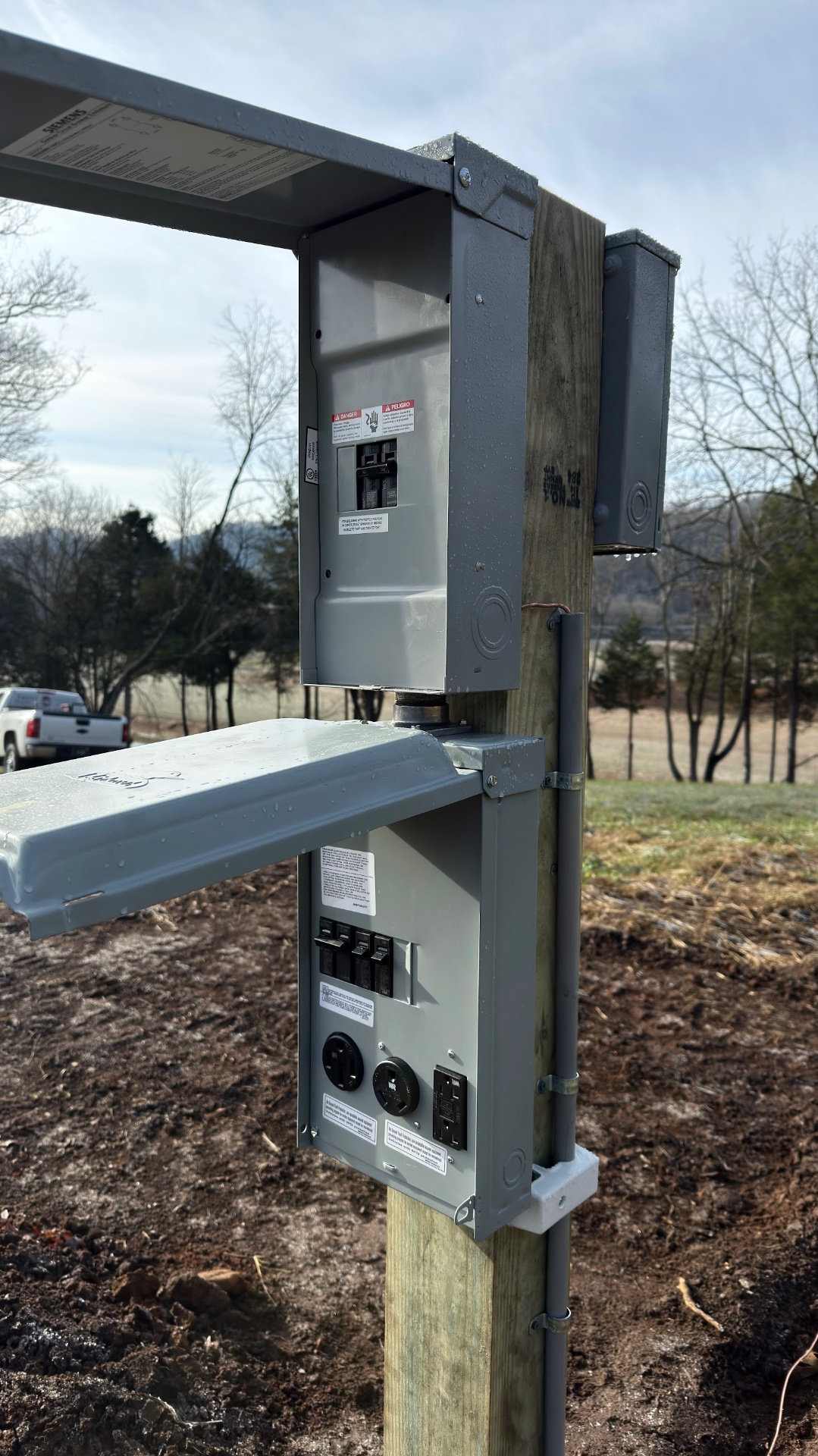 Pole-mounted meter, breaker enclosure and RV-style outlet panel installed on a rural East Tennessee property