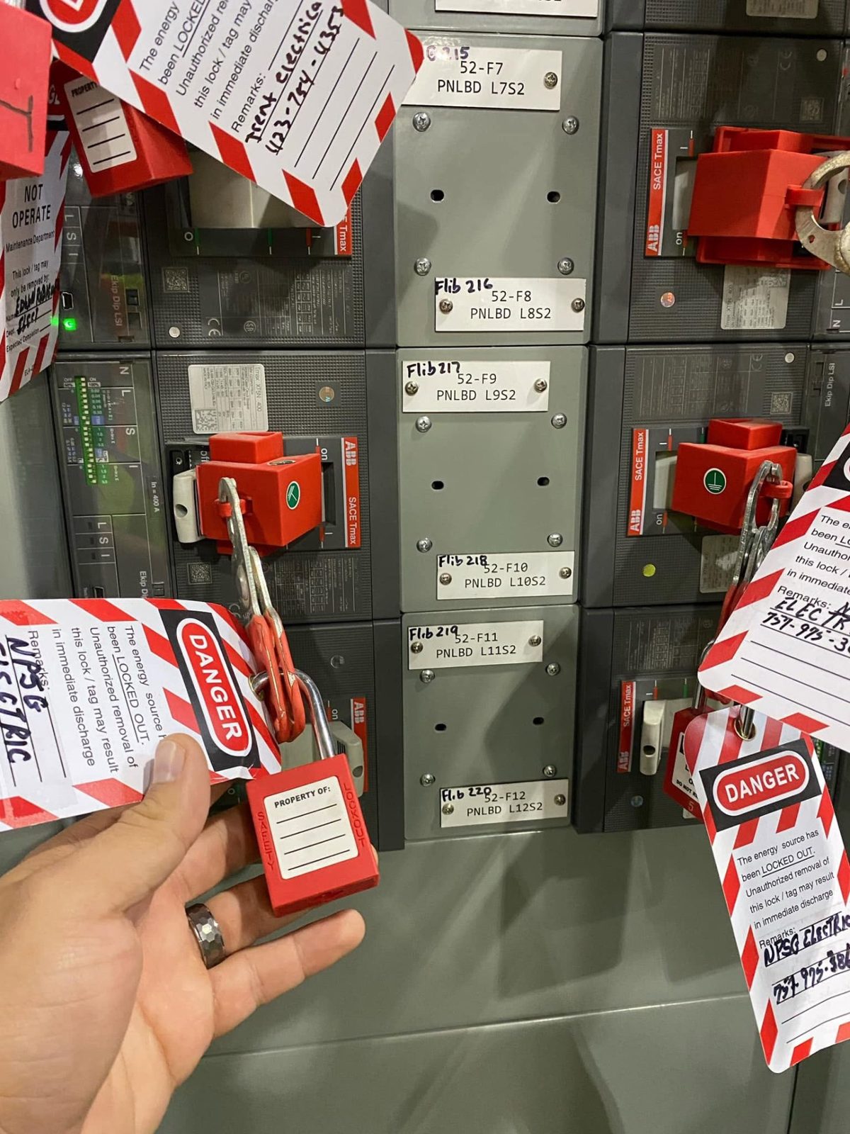 Lockout tagout locks and tags applied to an industrial electrical panel before service work