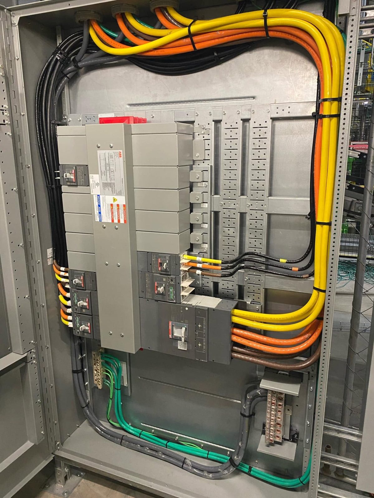 Color-coded conductors landed neatly inside a large electrical panel