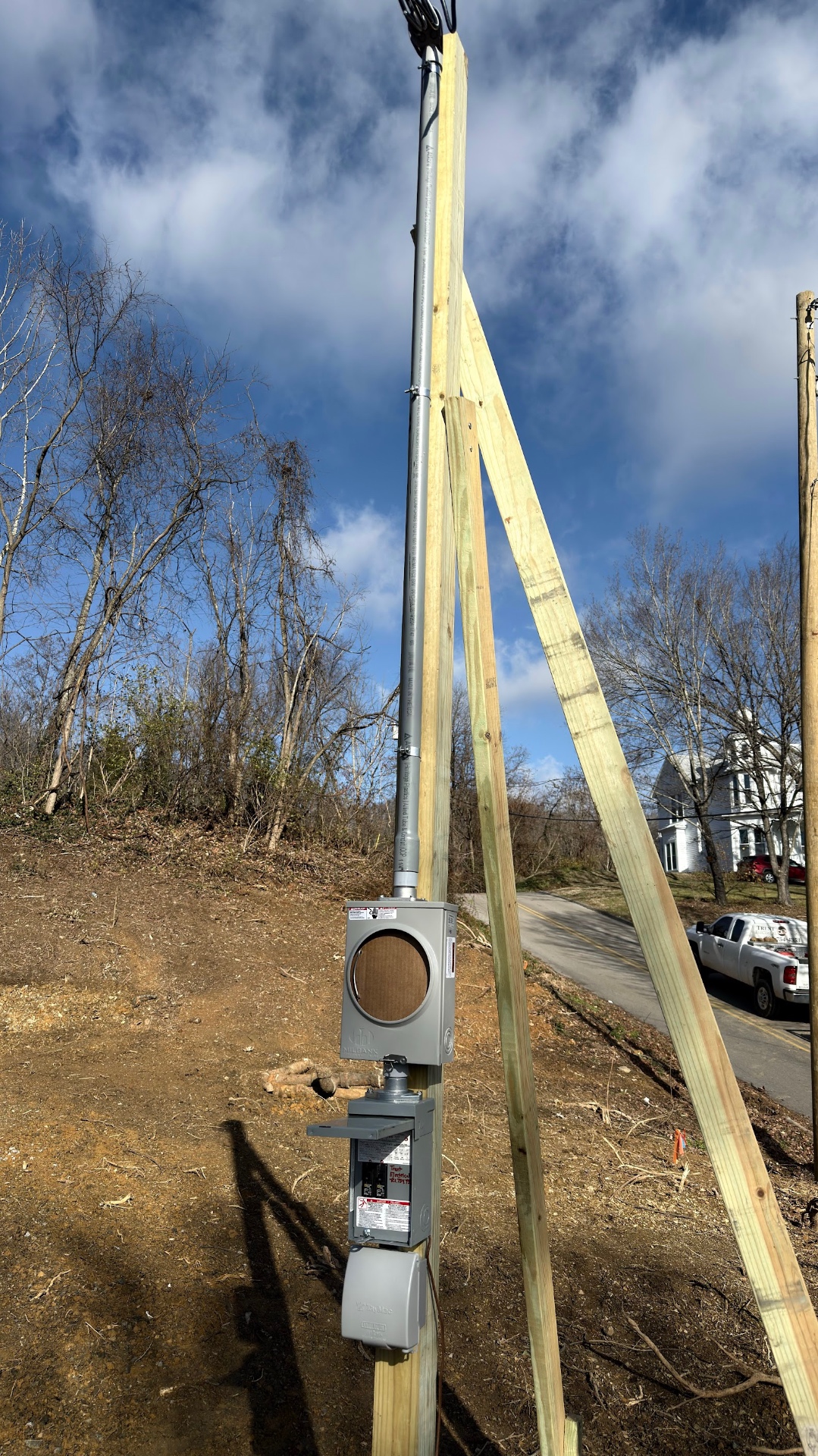 Temporary power pole with meter base and disconnect set on a hillside building site in Hawkins County TN