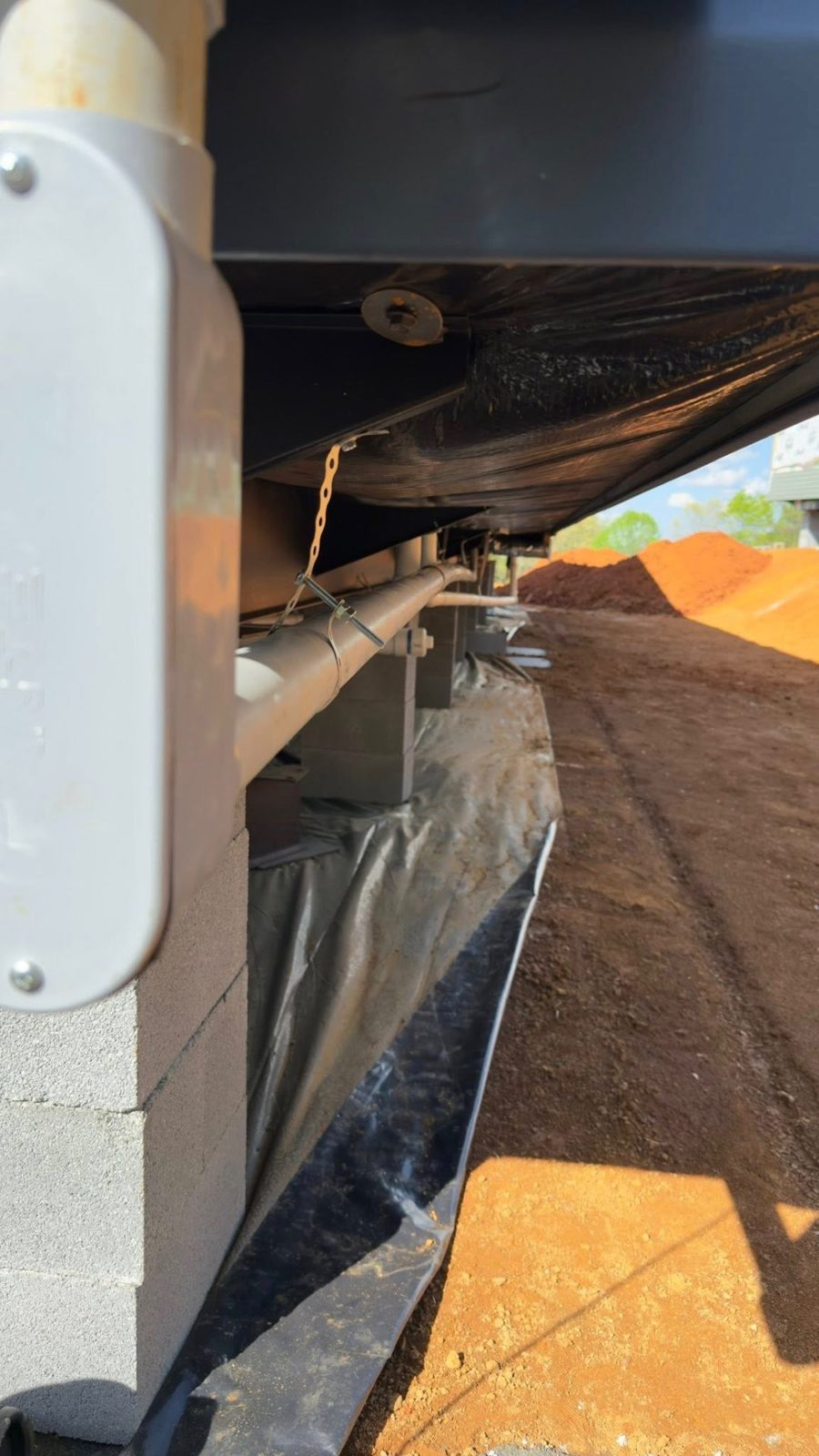 Electrical conduit run along the footer of a building under construction
