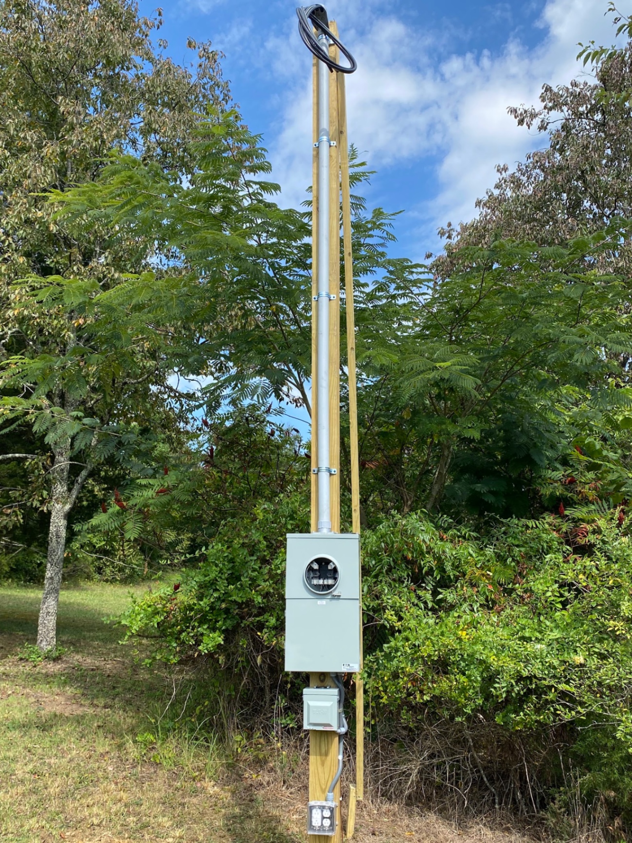 Pole-mounted meter base and weatherproof outlet on a wooded East Tennessee property