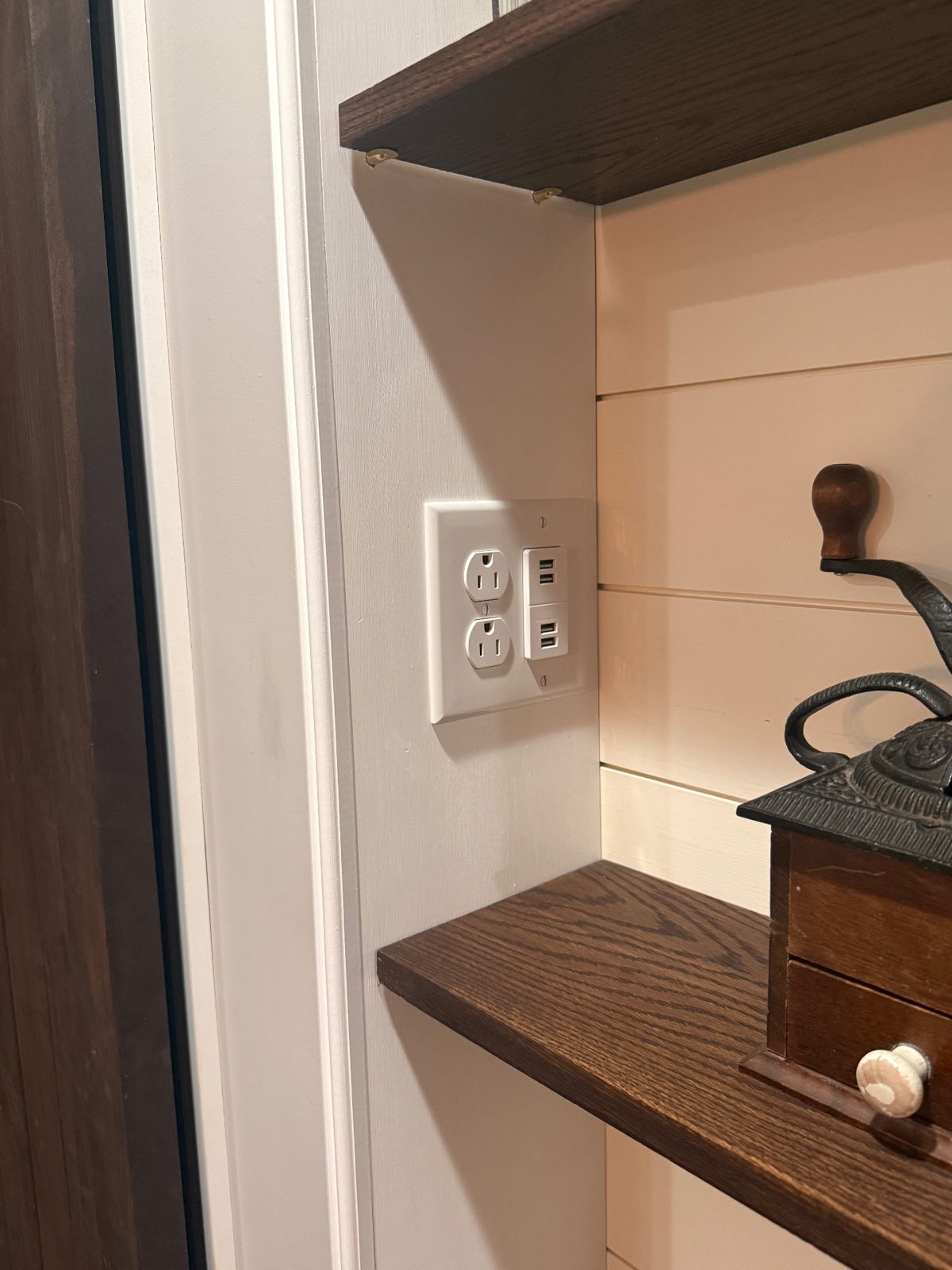 Outlet with built-in USB charging ports installed in a white shiplap wall